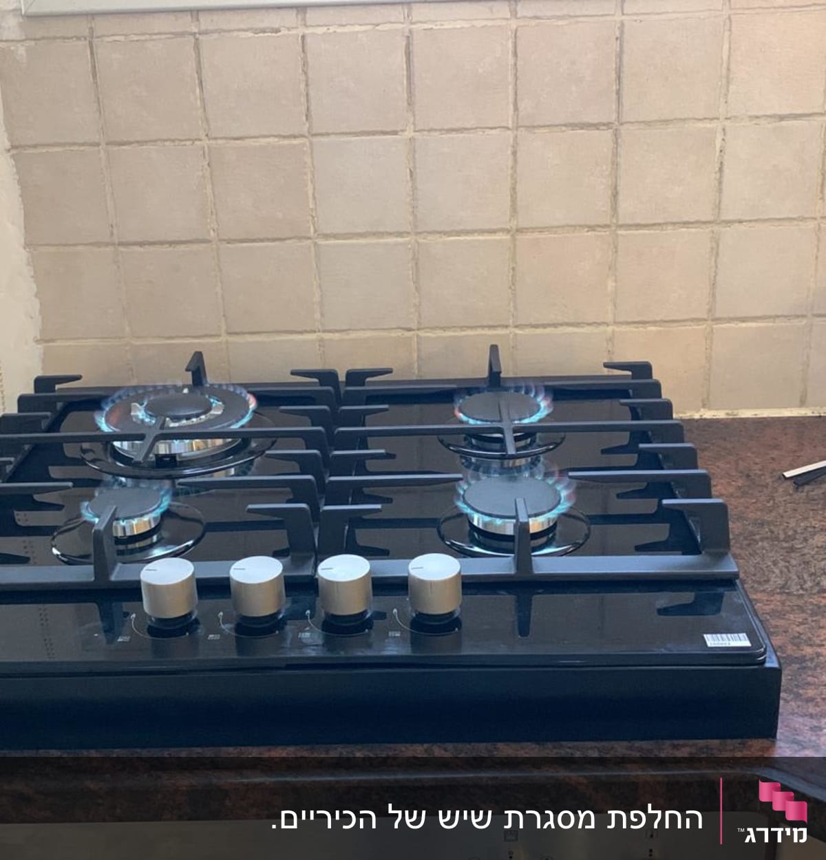 כיריים על משטח שיש חום כהה במטבח